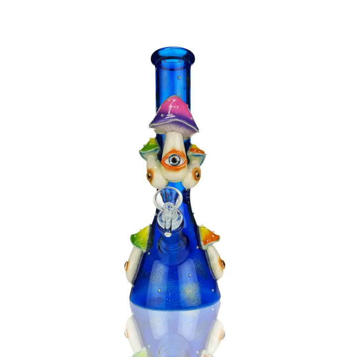 A vibrant blue beaker-style water pipe adorned with numerous colorful mushrooms, some featuring an eye design on their stems, set against a clean white background.
