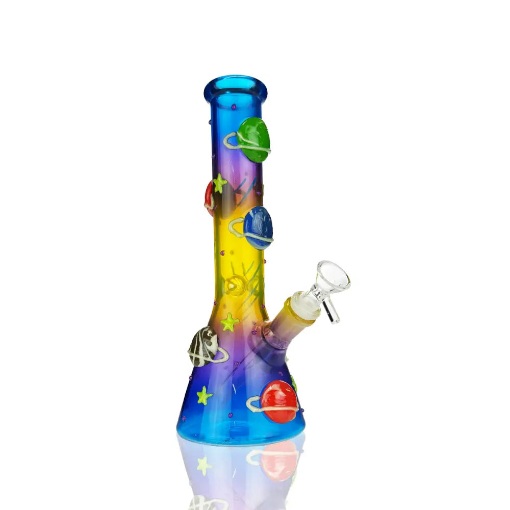 Front view of a vibrant, multi-colored glass beaker water pipe adorned with 3D planet and star embellishments, set against a white background.