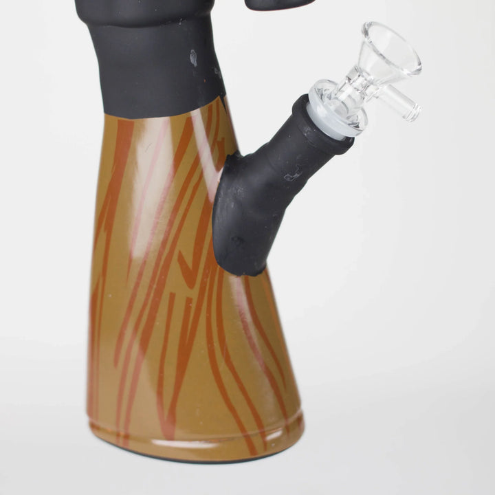 A vibrant fumed glass spoon pipe, featuring a light yellow body with intricate teal and blue-green swirling patterns, and a red wavy design near the mouthpiece, set against a white background.