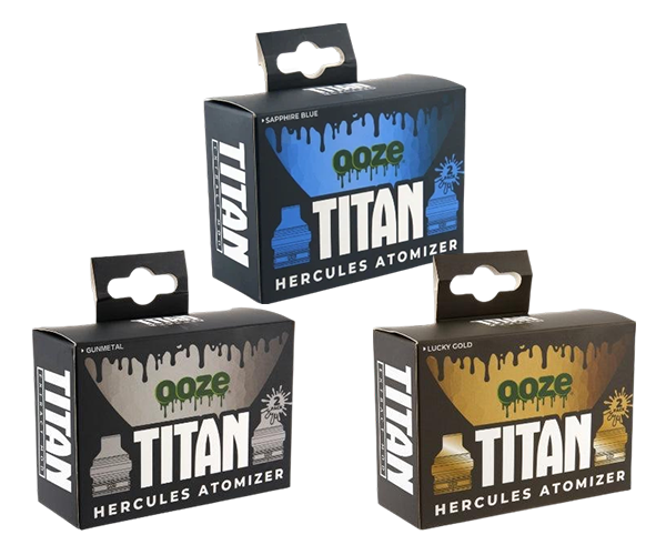 Three black product boxes, each with a different color accent: blue, silver, and gold, featuring 'Ooze Titan Hercules Atomizer' branding and a dripping paint design.