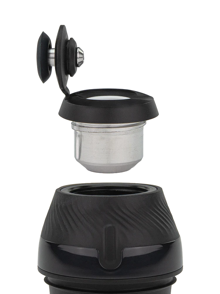 Detail shot of a portable vaporizer's disassembled components, showing the black silicone cap with a metal insert and the textured black base.