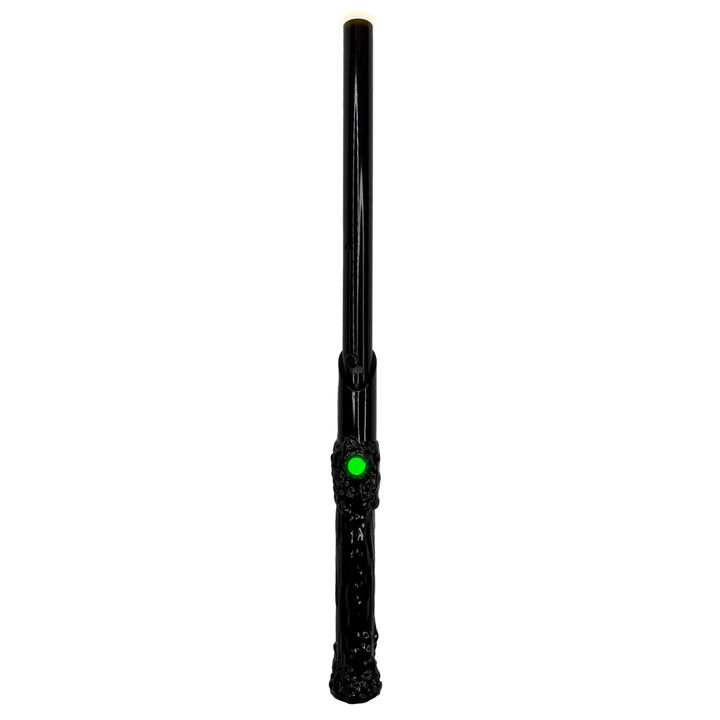 A sleek black wand-shaped 510 vape battery with a glowing green button and a subtle yellow glow at its tip, presented vertically against a dark background.