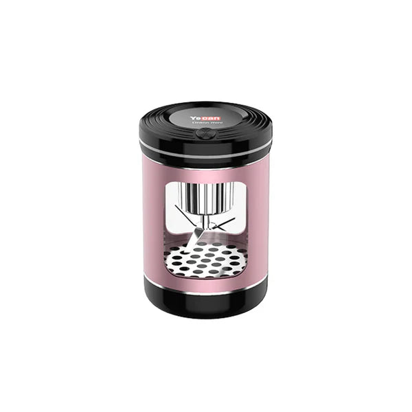 A rose gold and black cylindrical dry herb grinder with a visible internal grinding mechanism and a perforated base.