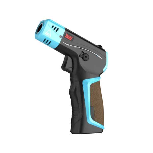 Angled view of a black and light blue pistol-grip butane torch with a brown textured grip, featuring a warning symbol and 'Yocan' branding on the barrel.