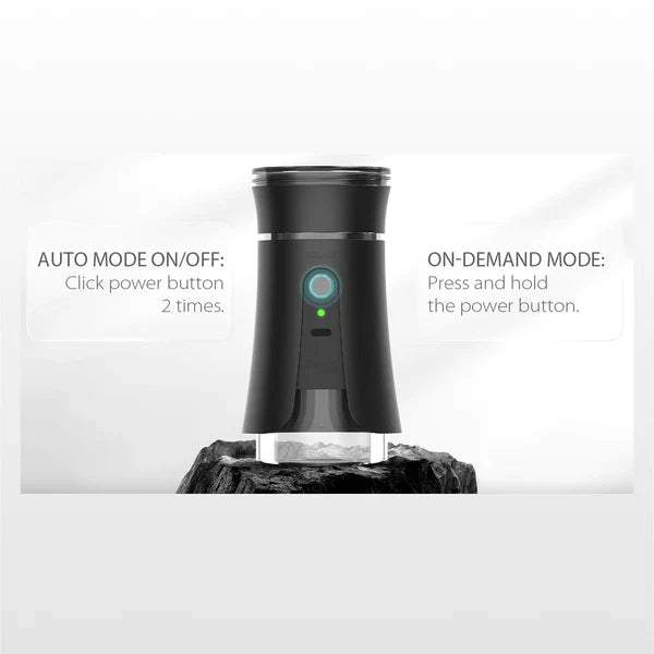 Detail shot of a black electric dry herb grinder, showing operating instructions for auto and on-demand modes with a green indicator light.