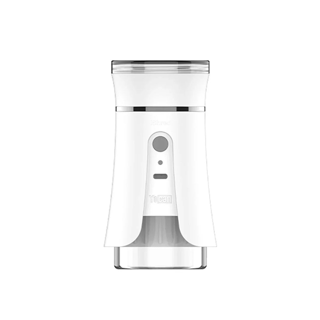 Front view of a white electric dry herb grinder with a clear bottom section and a clear top lid. It features a gray control button and small indicator lights on its front.