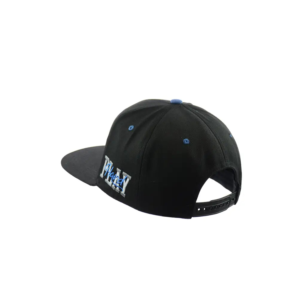Rear-side view of a black baseball cap with a flat brim, featuring 'PLAY' embroidered in white and blue on the side, and a black snapback closure.