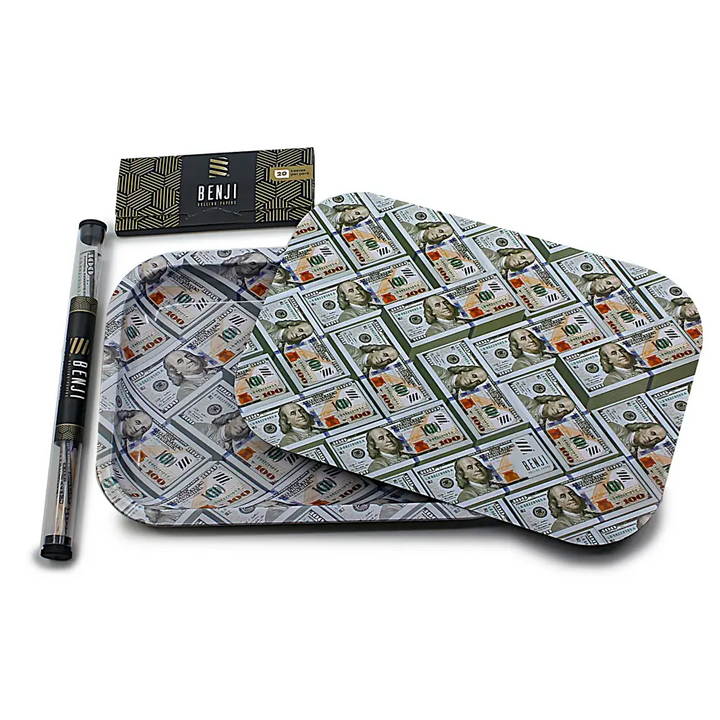 A rolling tray kit featuring a rectangular tray and a lid, both covered in a pattern of hundred-dollar bills. Beside it is a black box of rolling papers and a clear tube containing rolling tips, all branded 'BENJI'.