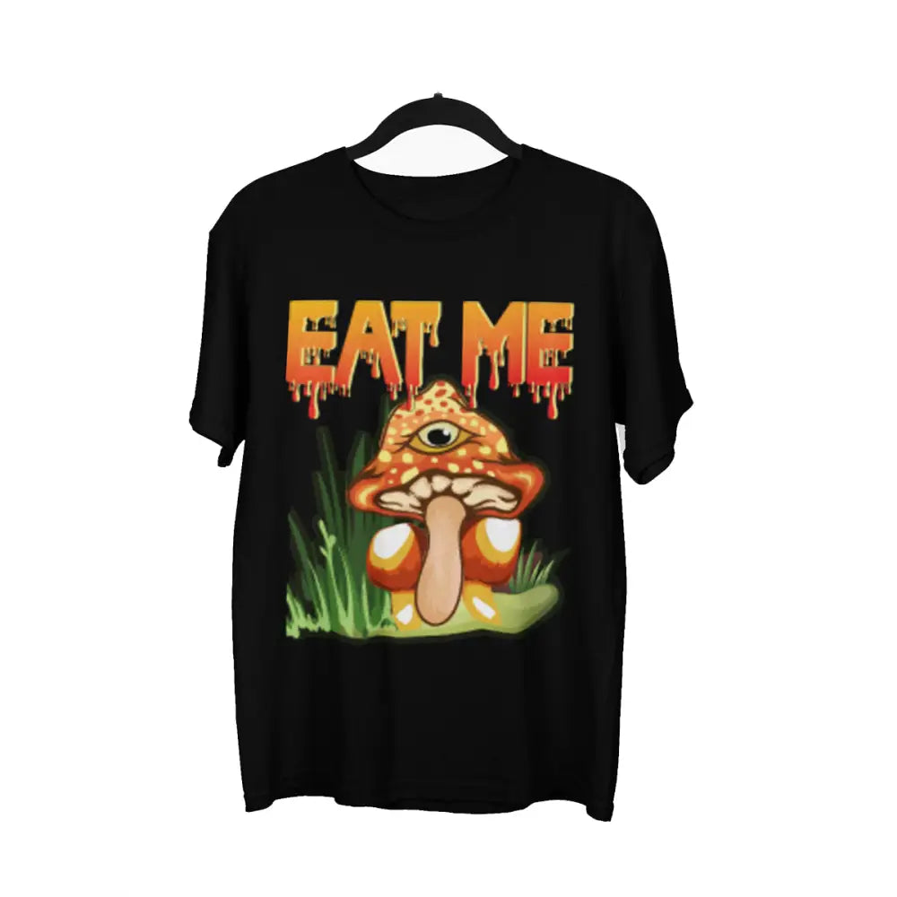 A black t-shirt featuring a vibrant graphic of an orange and yellow mushroom with a single eye, surrounded by green grass, and the words 'EAT ME' in dripping orange and yellow letters above it.