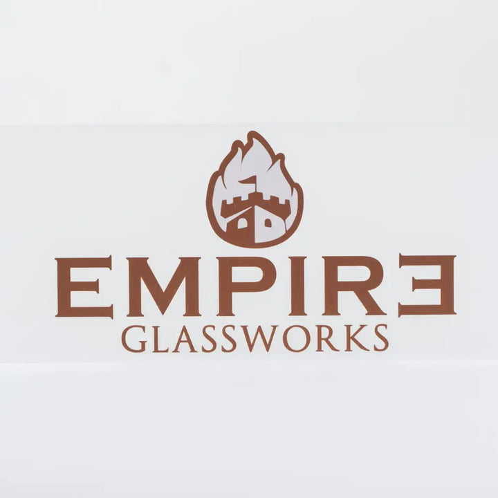Close-up of the Empire Glassworks logo, featuring a brown castle icon with flames above it, and the words 'EMPIRE GLASSWORKS' in brown text below, all on a white background.