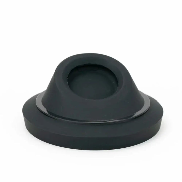A black, circular display stand with a sloped, conical top featuring a recessed circular opening, and a thin metallic ring around its base.