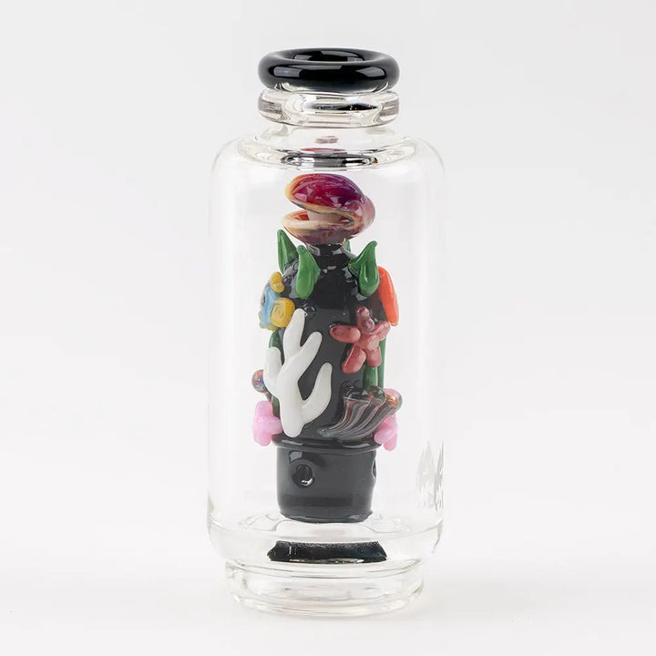 A clear glass vaporizer attachment featuring an intricate, colorful underwater reef scene with coral, a clamshell, and seaweed, all encased within the cylindrical glass.