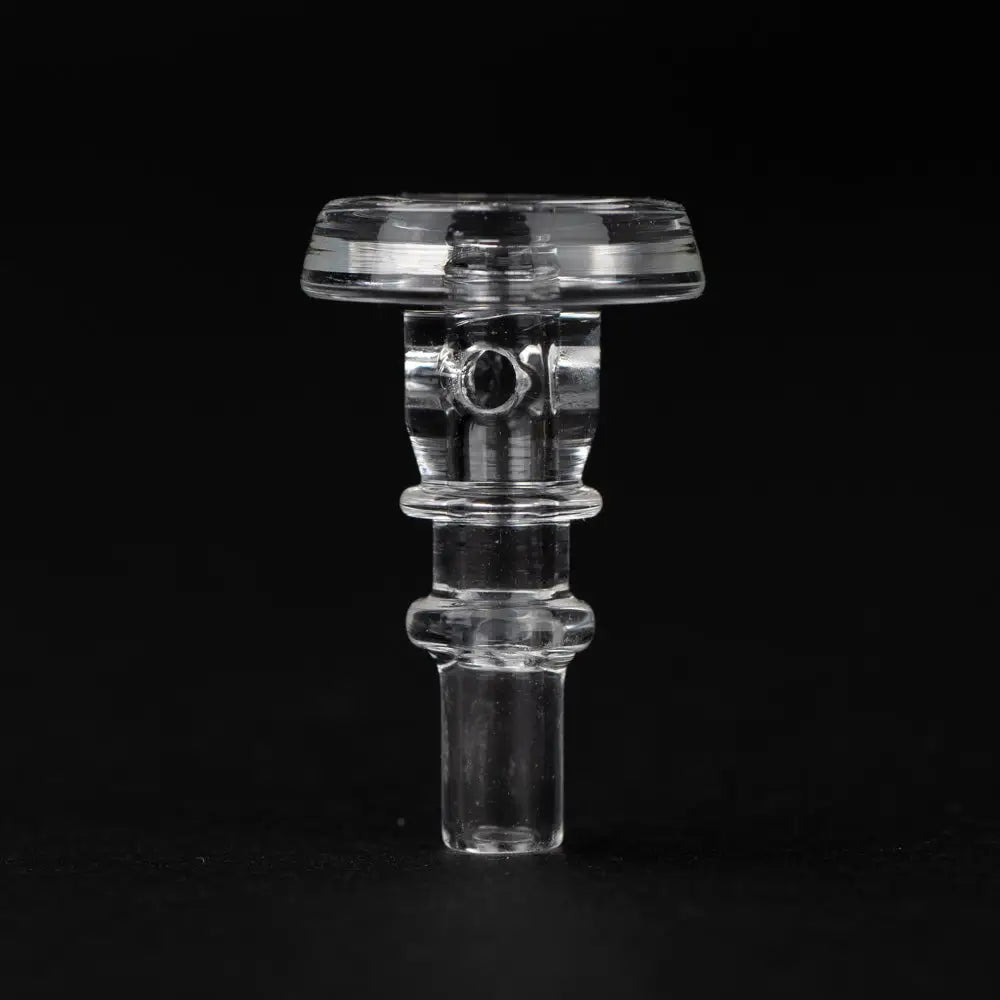 Close-up detail shot of a clear glass accessory, likely a Puffco joystick cap, featuring a cylindrical body, flat top, and small stem, against a dark background.
