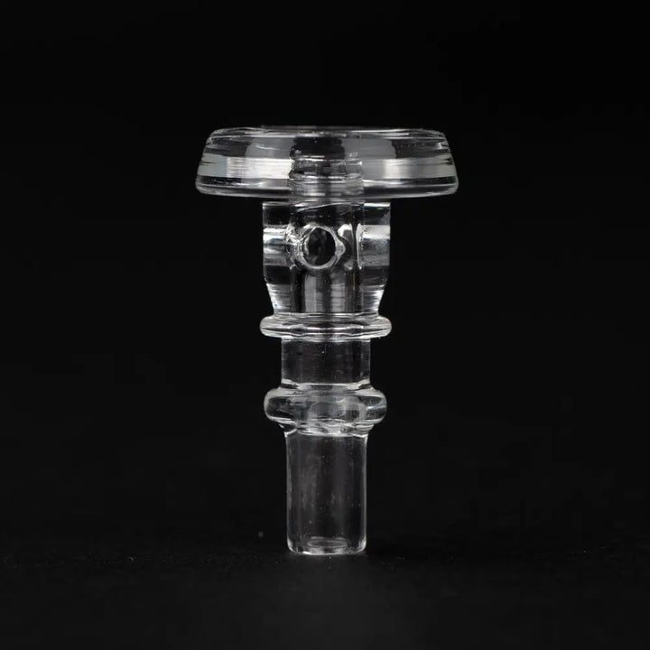Close-up detail shot of a clear glass accessory, likely a Puffco joystick cap, featuring a cylindrical body, flat top, and small stem, against a dark background.