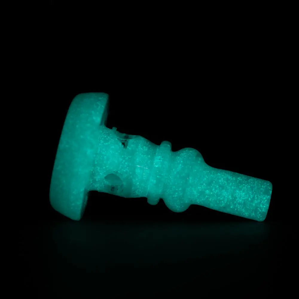 Close-up of a glowing teal attachment for a vaporizer, featuring a flat base and a tapered, ridged body, set against a dark background.