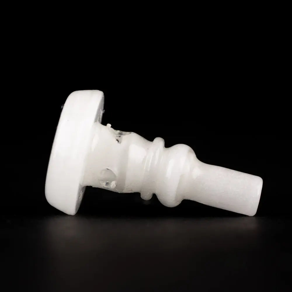 Side view of a white, glow-in-the-dark glass attachment with a flat base and a ridged, tapered body, set against a dark background.