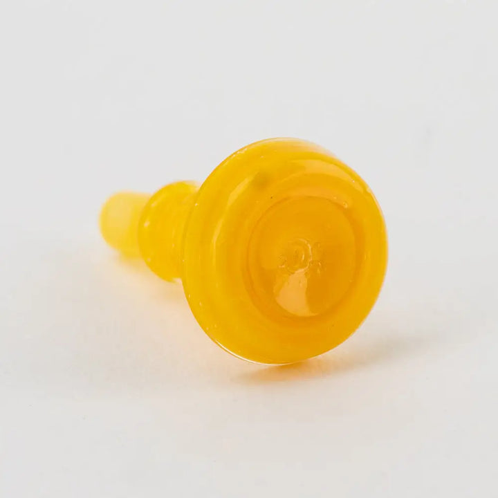 Close-up view of a small, bright yellow glass accessory, cylindrical in shape with a wider, flat top and a tapered base, against a white background.