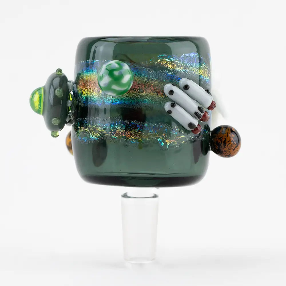 Close-up of a dark green glass attachment with a space theme, featuring a UFO, planets, and rockets, designed for a Puffco Proxy, against a white background.