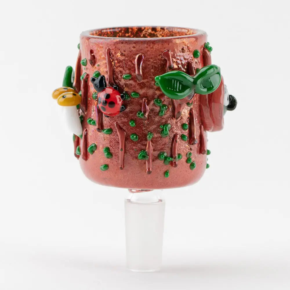 Close-up, front-facing view of a brown glass bowl piece designed like a tree stump, adorned with green leaves, a red ladybug, and white and yellow mushrooms.