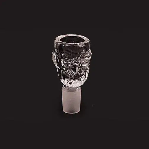 Clear glass smoking bowl shaped like a detailed skull head with glasses, featuring a frosted male joint, presented against a dark background.