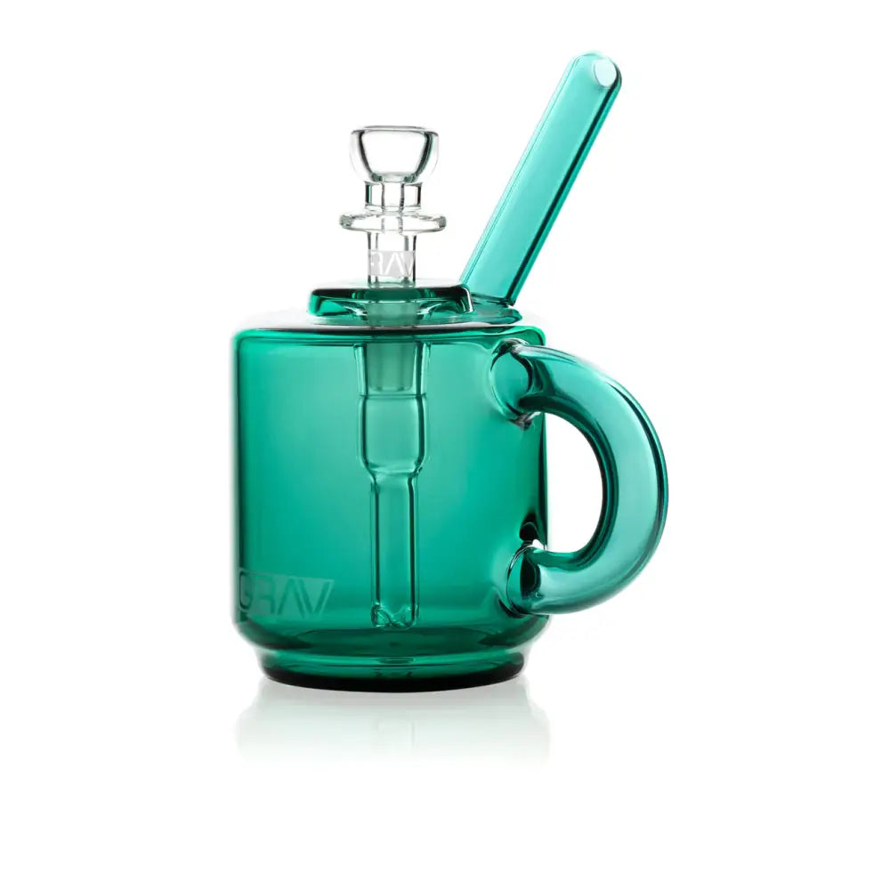 Teal green glass bubbler shaped like a coffee mug with a handle, clear glass bowl, and angled mouthpiece on a white background.