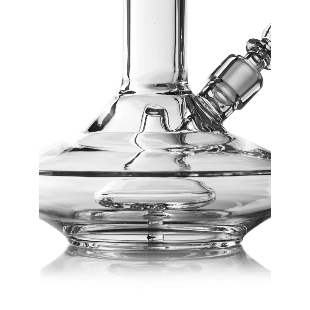 Detail shot of the clear glass base of a wide base water pipe, showing the submerged percolator with small holes and the water level, against a white background.