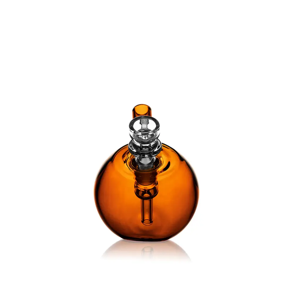 A spherical amber glass pocket bubbler with a clear glass mouthpiece and downstem, reflecting on a white surface.