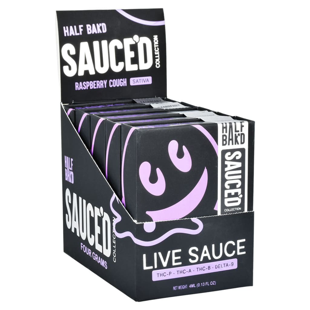 A black display box filled with multiple individual black and purple vape product packages, featuring a smiling purple blob logo.