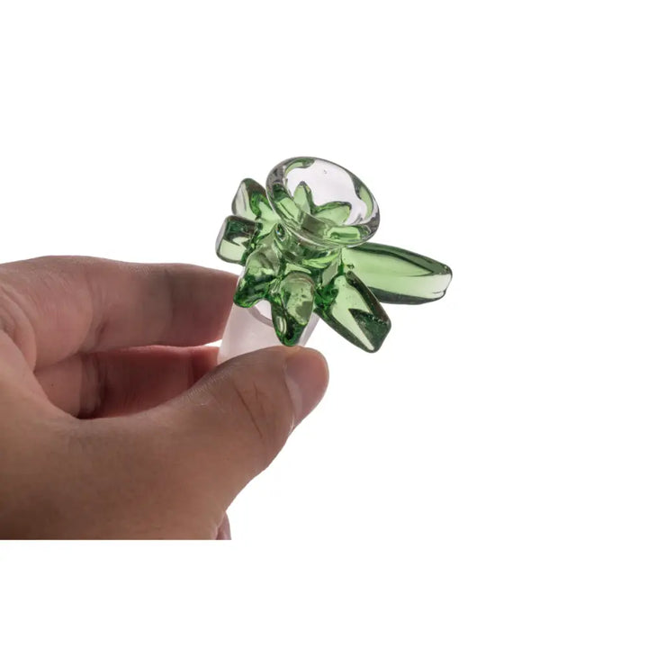 A hand holds a green glass bowl with a flower-like design and an 18mm male joint, shown against a white background.