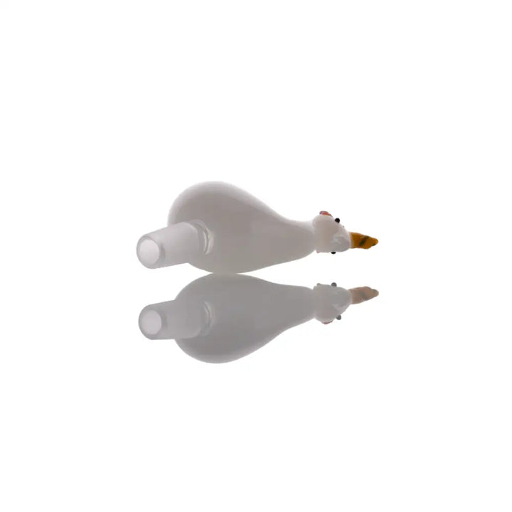 A white glass bowl shaped like a duck with a yellow beak and small red eyes, lying on its side with a clear reflection below it on a white surface.