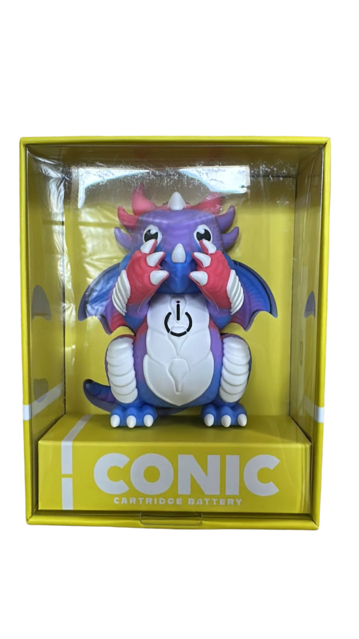 A dragon-shaped vape battery, primarily purple and blue with red accents, is displayed inside a clear plastic window of a bright yellow retail box. The box has 'ICONIC CARTRIDGE BATTERY' printed on its base. This image shows the product in its packaging.