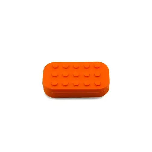 An orange, rectangular silicone container with rounded edges and Lego-style studs on its top surface, centered against a plain white background.