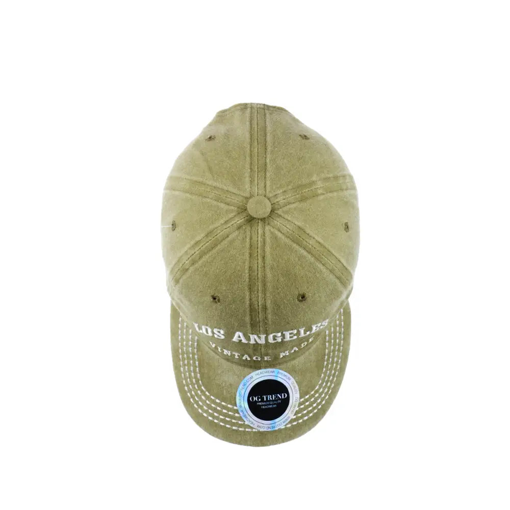 Top-down view of a distressed olive green baseball cap with 'LOS ANGELES' and 'VINTAGE MADE' embroidered in white on the brim, featuring white stitching and a circular sticker on the brim.