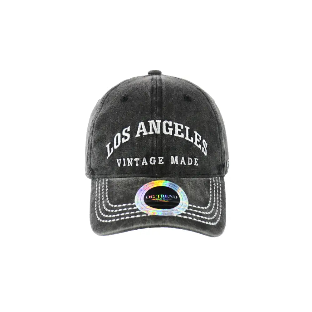 Front view of a dark grey distressed baseball cap with 'Los Angeles' and 'VINTAGE MADE' embroidered in white, featuring a holographic sticker on the brim.