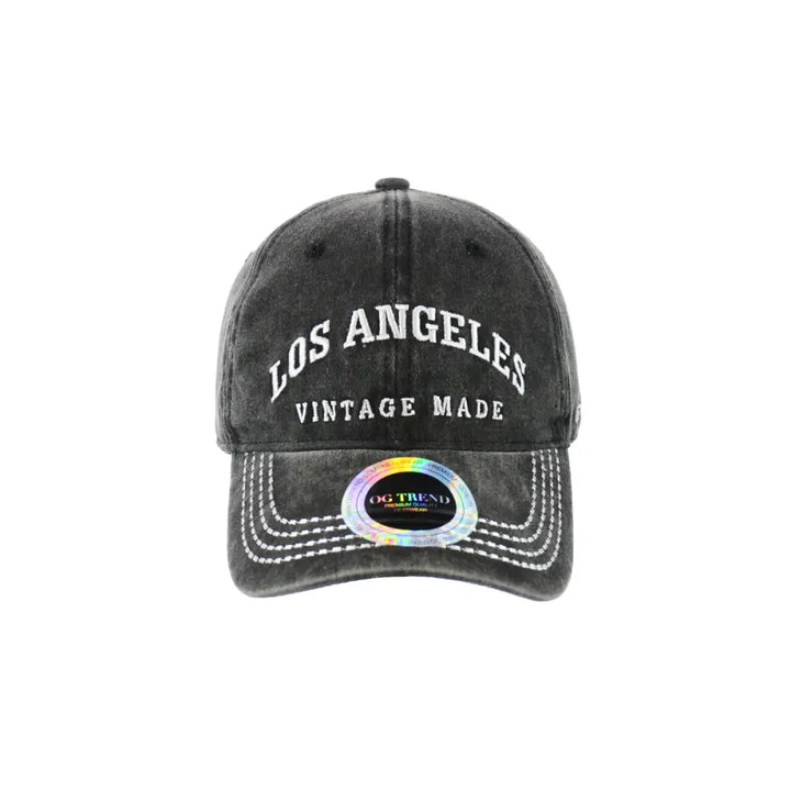 Front view of a dark grey distressed baseball cap with 'Los Angeles' and 'VINTAGE MADE' embroidered in white, featuring a holographic sticker on the brim.