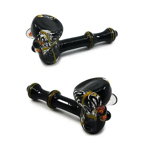 Two views of a black glass hand pipe with swirling yellow and orange marble-like patterns, shown against a white background.