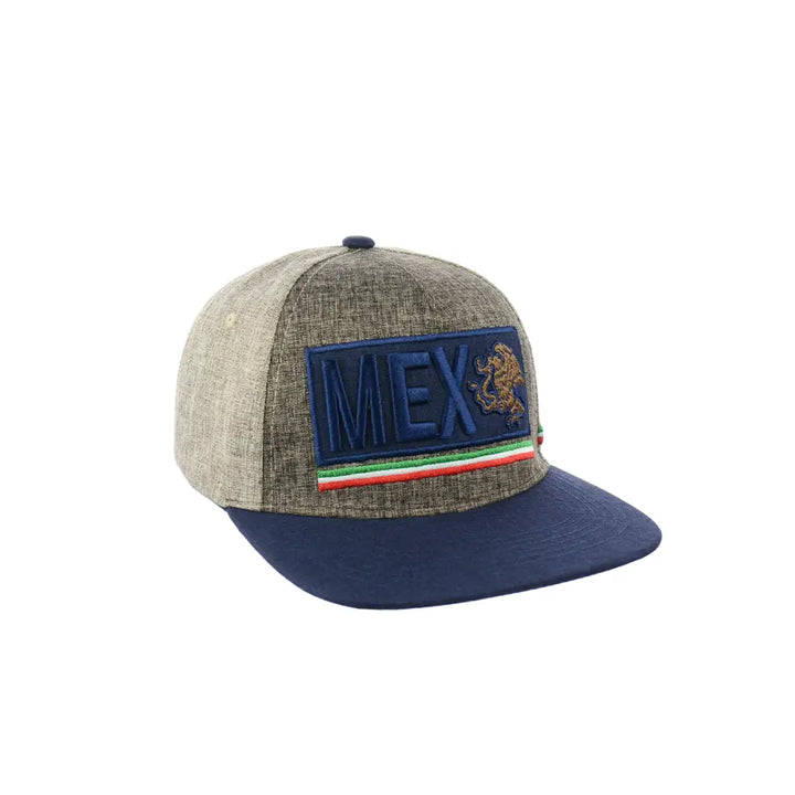 Close-up view of a snapback hat featuring a heathered grey crown and a dark blue brim. The front has a rectangular dark blue patch embroidered with 'MEX' and a golden lion or eagle emblem, accented by red, white, and green stripes.