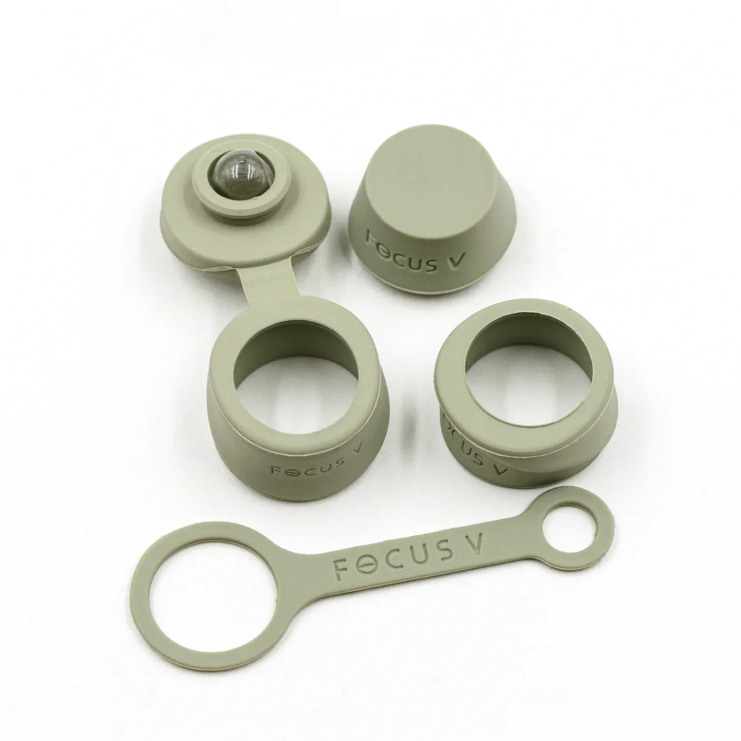A set of light green silicone accessories for a vaporizer, including caps, rings, and a strap, laid out on a white surface.