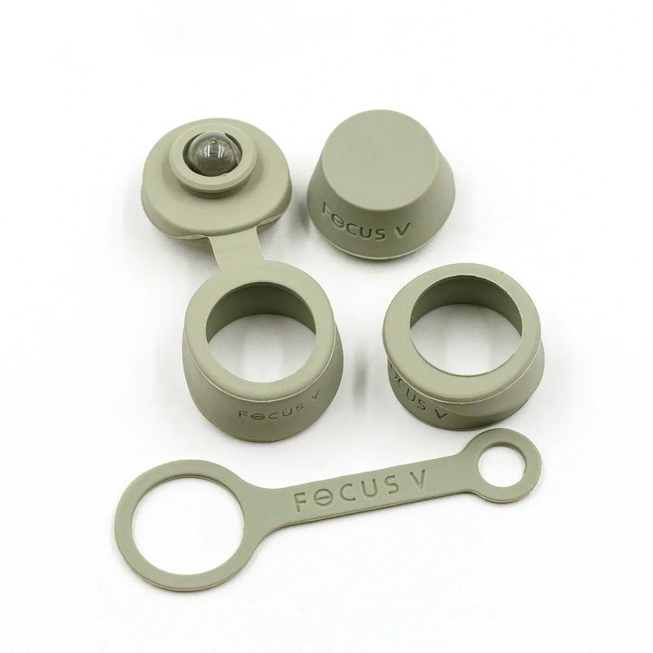 A set of light green silicone accessories for a vaporizer, including caps, rings, and a strap, laid out on a white surface.