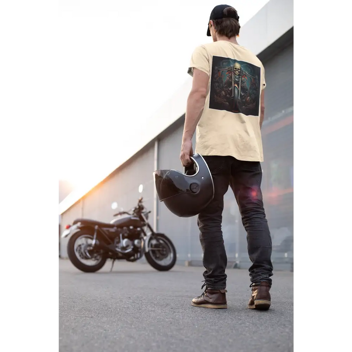 Rear view of a man wearing an off-white t-shirt with a skull graphic, holding a motorcycle helmet, standing next to a black motorcycle at sunset.
