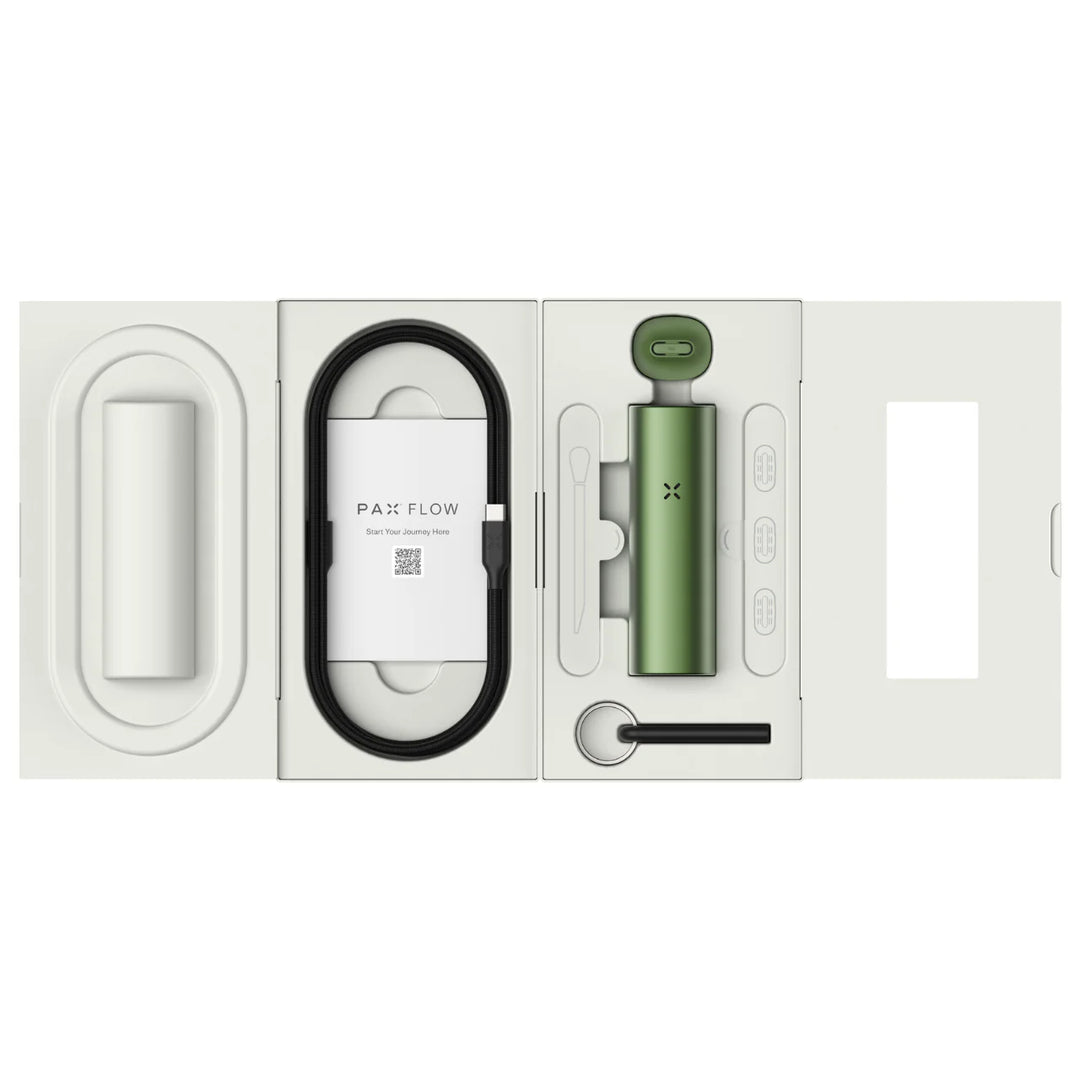 Overhead view of an unboxed green portable dry herb vaporizer and its accessories, including a charging cable and cleaning tools, laid out in a white molded packaging insert.