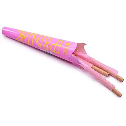 A pink, tapered package with yellow 'PINK' branding, partially open to reveal several pink pre-rolled cones with natural-colored tips, laid diagonally on a white background.