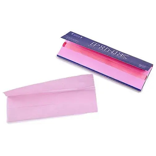 A dark blue rectangular pack of pink rolling papers with white text, displayed alongside a single unfolded pink rolling paper, all on a clean white background.