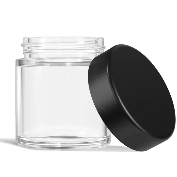 Clear glass jar with a black screw-on lid resting beside it, showcasing the jar's threads.