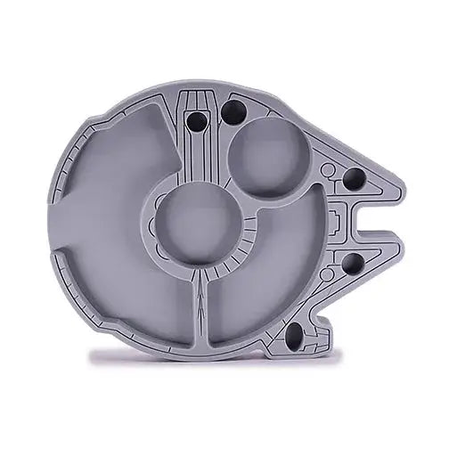 Top-down view of a gray silicone tray shaped like the Millennium Falcon, featuring multiple circular and irregular compartments for organization.