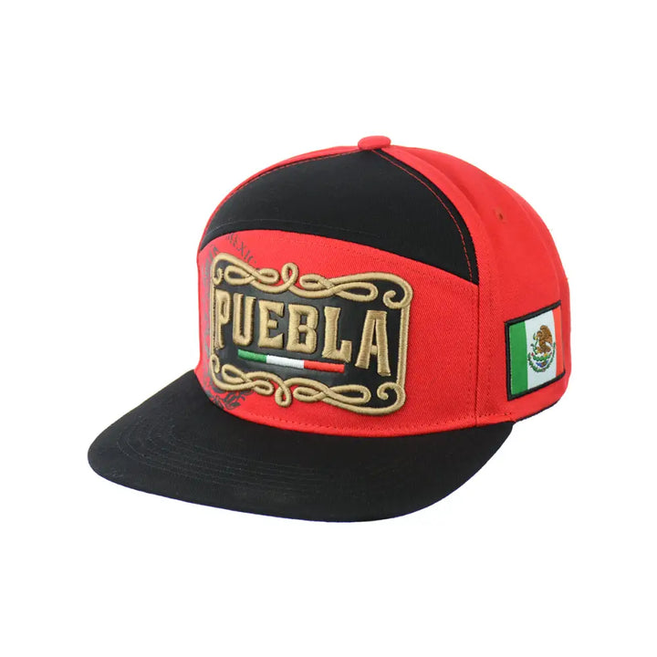 A red and black snapback hat featuring 'PUEBLA' embroidered in gold with scrollwork on the front, and a Mexican flag patch on the side.