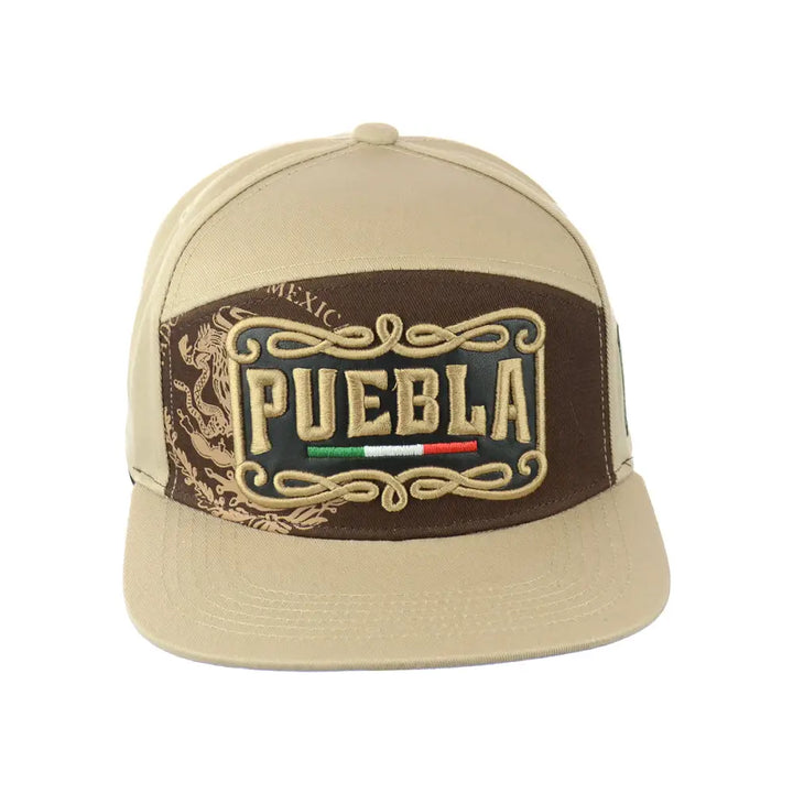 Close-up front view of a beige snapback hat with a brown embroidered patch featuring 'PUEBLA' text, a Mexican flag, and ornate scrollwork.