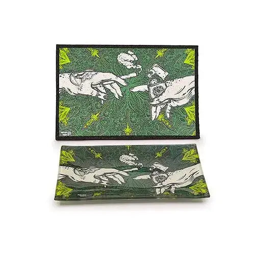 Two rectangular items, a mat and a glass tray, both featuring a green background with a white and black illustration of two hands, one holding a lit joint and the other a lighter, with smoke between them.
