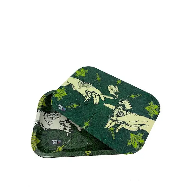 An overhead shot of a green metal rolling tray with a matching lid, both featuring a cream-colored 'Creation of Adam' parody design with hands, a lighter, and cannabis buds. The lid is angled, partially revealing the tray below, against a white background.