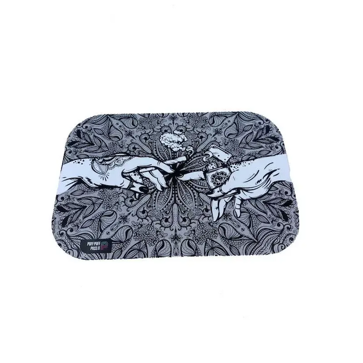 Rectangular metal rolling tray with rounded corners, featuring a black and white illustration of two hands reaching for a lit joint amidst intricate floral and mandala-like patterns. The text 'PUFF PUFF PASS IT' is visible in the bottom left.